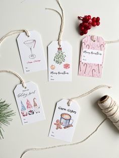 four christmas gift tags are hanging from twine