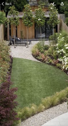 an outdoor garden with grass, rocks and flowers