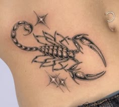 a scorpion tattoo on the side of a woman's stomach, with stars around it