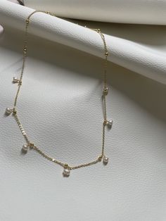 This necklace is handcrafted in brass with an elegant touch with the precious pearl charm attached. It's so minimalist but sophisticated, elegant but classy, simple but unique! It can match almost everything in your closet! //Materials// ✔️ pearl  ✔️ Chain, brass //Necklace Length// 18"  //Special Notes// **Feel free to ask me anything if you have concerns ! Fresh water pearl Minimalist Briolette Pearl Drop Jewelry, Minimalist Pearl Drop Briolette Jewelry, Minimalist Drop Pearl Chain Necklace, Gold Dangle Charm Necklace With Pearl Drop, Dainty Pearl Charm Necklace In 14k Gold, Gold Pearl Necklace With Clavicle Chain Dangle, Dainty 14k Gold Necklace With Pearl Charm, Adjustable Gold Charm Necklace With Pearl Chain, Adjustable Gold Pearl Charm Necklace