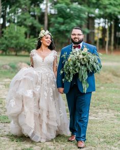 a bride and groom walking through the grass