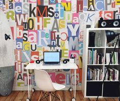 there is a desk with a laptop on it in front of a bookcase and a surfboard