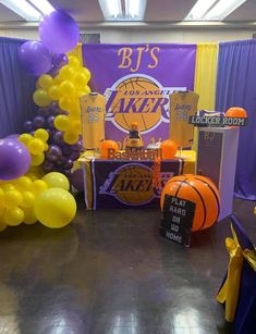 an indoor basketball themed party with balloons and decorations on the floor, along with signs that read lakers