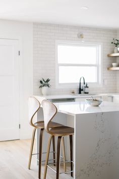 two stools sit at the center of a kitchen island