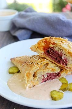 two pastries on a white plate with pickles