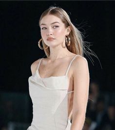 a woman in a white dress on the runway