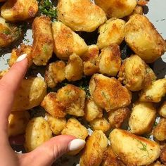 someone is pointing at some fried potatoes on a plate