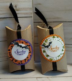 two halloween treat bags with tags attached to the handles, decorated with pumpkins and bats