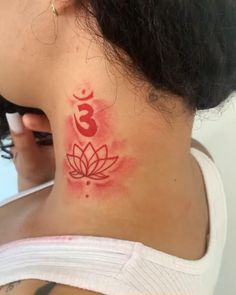 the back of a woman's neck with a red and white tattoo on it