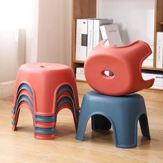 two children's stools sitting on the floor in front of bookshelves