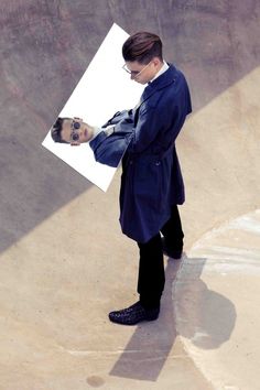 a man standing in front of a skateboard ramp with his hand on the board