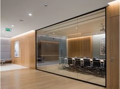 an empty conference room with glass walls and wooden floors