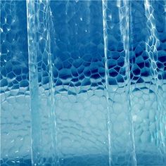 an abstract photo of blue glass with wavy lines and bubbles in the water behind it