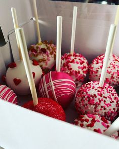 a box filled with cake pops covered in sprinkles and topped with strawberries