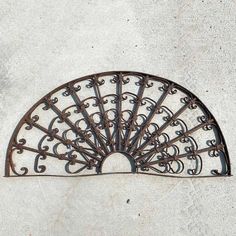 an iron fan sitting on the side of a wall next to a cement flooring