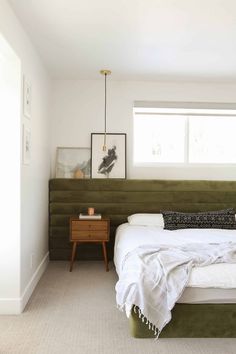 a bedroom with a bed, nightstands and pictures on the wall above it's headboard