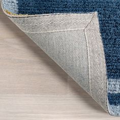 a blue and white rug on top of a wooden floor next to a wood floor