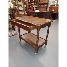 a wooden table sitting on top of a floor next to other furniture and decor items