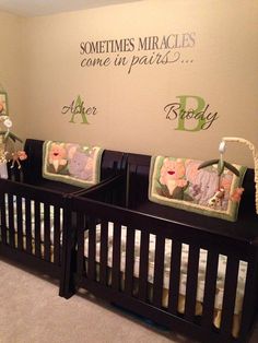 two baby cribs in a room with wall decals