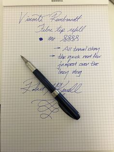 a pen sitting on top of a piece of paper next to a note pad with writing