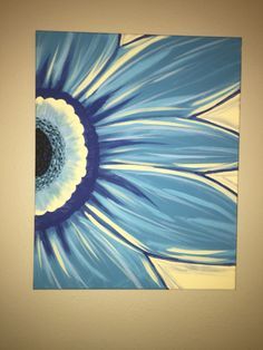 a blue and white flower painted on a canvas mounted to a wall in a room