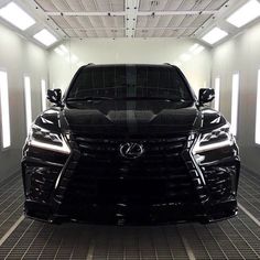 the front end of a black car parked in a garage