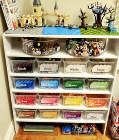 a book shelf filled with legos and other toy storage bins on top of it