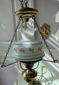 an old fashioned tea kettle hanging from a chain