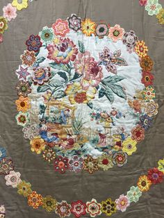 a quilted wall hanging with flowers on it