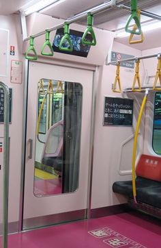 the inside of a subway car with pink flooring and neon green lights hanging from the ceiling