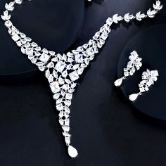 a diamond necklace and earring on black background