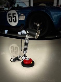 a lamp that is sitting on top of a table in front of a race car