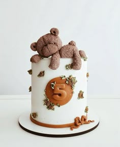 two teddy bears sitting on top of a white cake