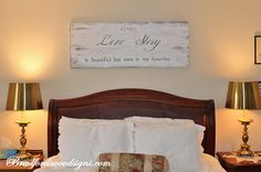 a bed with two lamps on either side and a sign above it that says love slay