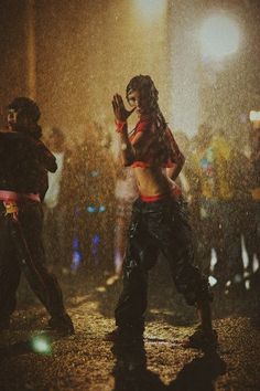 two people dancing in the rain at night