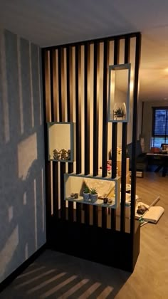 a living room filled with furniture next to a wall mounted book shelf on top of a hard wood floor