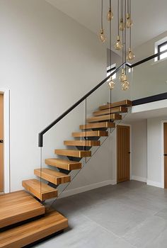 a staircase with wooden steps and chandelier hanging from the ceiling