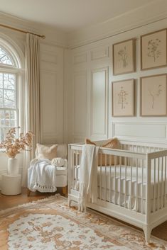 a baby's room with a crib, rocking chair and pictures on the wall