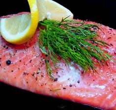 a piece of salmon with lemon and dill garnish