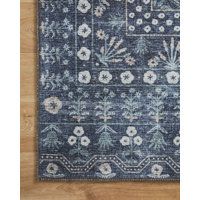 a blue and white rug with flowers on the bottom is laying on a wooden floor