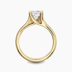 a yellow gold engagement ring with a single diamond in the center, on a white background