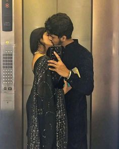 a man and woman kissing in an elevator