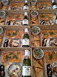 several boxes filled with different types of food and wine bottles on top of each box