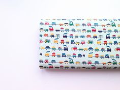 a blue wrapping paper with cars and trucks on it, sitting on a white surface