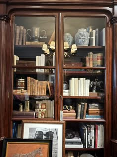 an old bookcase with many books and pictures on the shelves in front of it