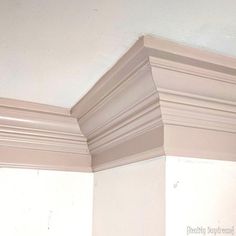 the corner of a room with white paint and molding on the wall above it