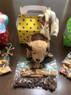 stuffed animals and snacks are on the table next to each other, including an elephant