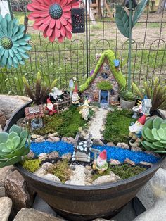 a potted planter filled with lots of green plants and small gnome figurines