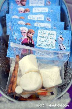 some marshmallows are in a bucket with tags on them that say do you want to build a snowman?