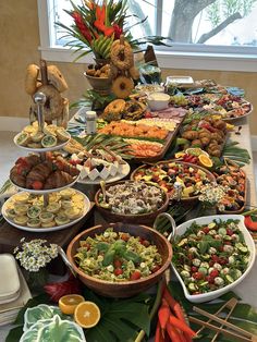 a buffet table filled with lots of food and fruit on it's sides,